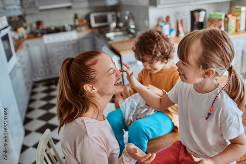 Mother and Children Having Fun While Eating in the Kitchen