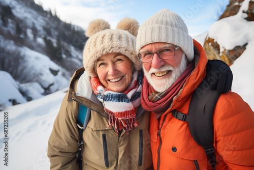 Portrait of happy senior couple looking at camera in winter mountains. Sunny day