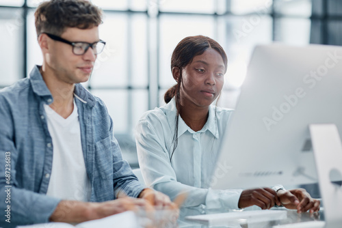 Cheerful businesspeople using a laptop in an office.