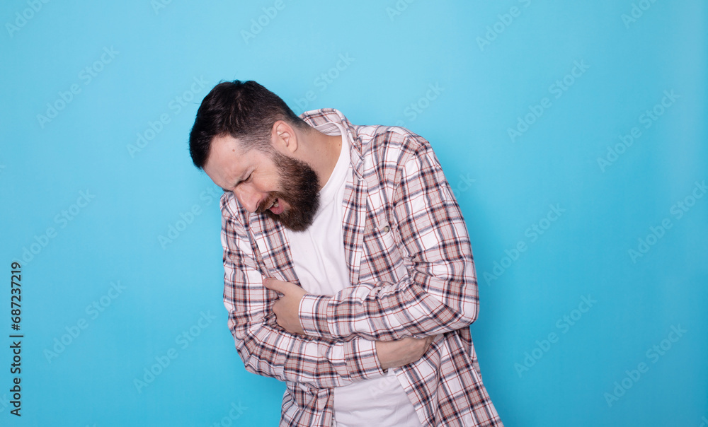 Man with abdominal pain health problem discomfort diarhea blue background. Man with abdominal pain health problem discomfort diarhea blue background.