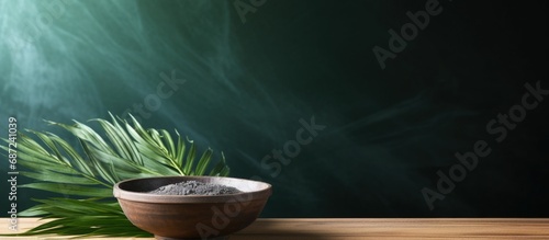 Stock photo of a bowl of ash with palm leave cross representing Lent Holy Week and Good Friday Copy space image Place for adding text or design photo