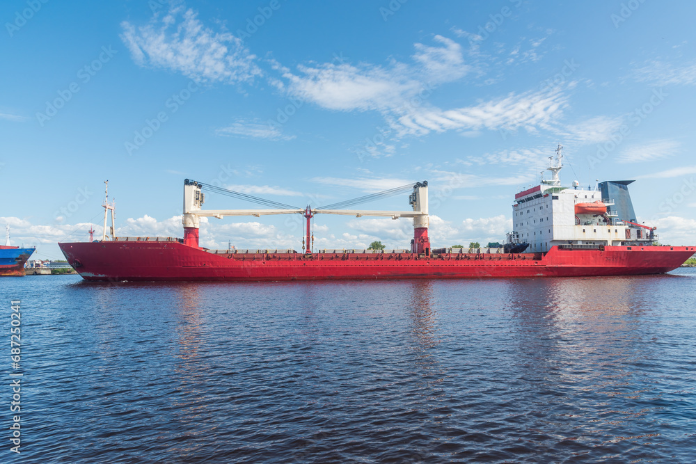 a large cargo ship on the roadstead on the river. background blue sky natural light.