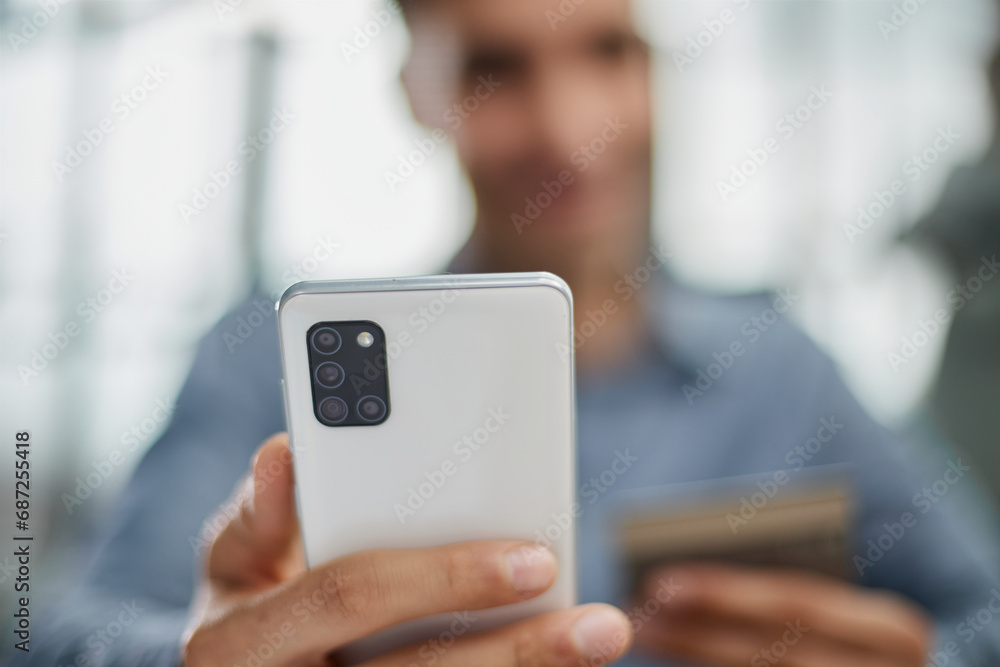 man selects a credit card from several and enters it number into a smartphone to pay online. Online shopping, lifestyle technology. man selects a credit card from several and enters it number into a smartphone to pay online. Online shopping, lifestyle technology.