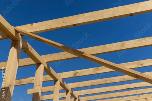 the wooden frame of the building against the blue sky