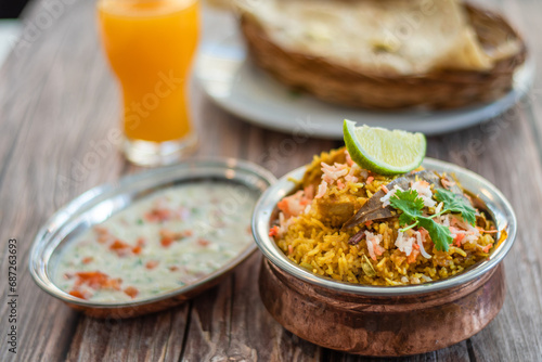 Spicy Indian biryani pulao in golden bowl with India basmati rice dish with chicken meat curry