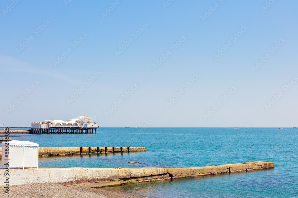 Piers in the Black Sea on a pebble beach in sunny weather