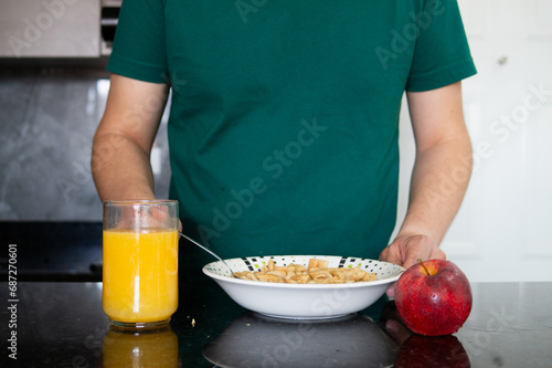 a man preparing a healthy breakfast with orange juice and cereal