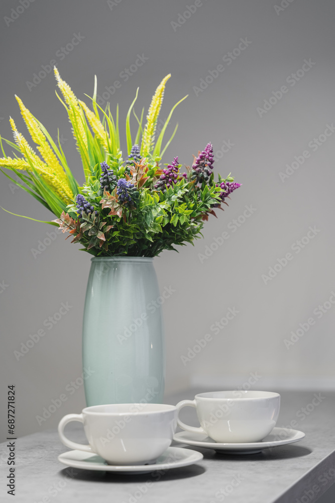 a vase of flowers and 2 white mugs on the table a vase of flowers and 2 white mugs on the table