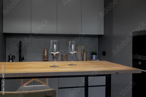 the kitchen is in shades of gray. Appliances. Wooden table and glass glasses