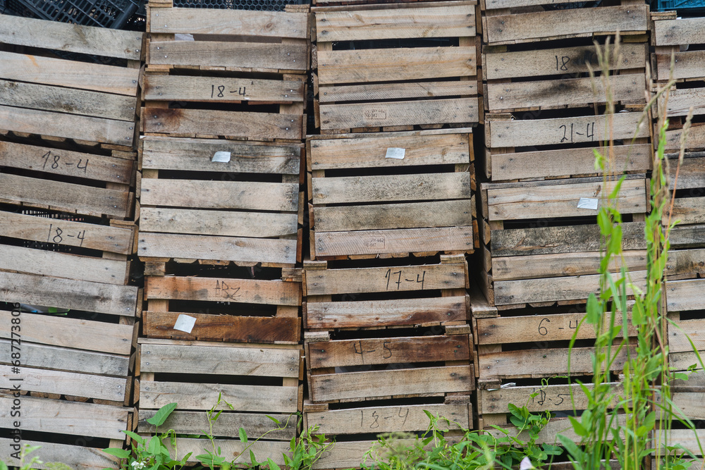 old wooden boxes stacked in stacks lie on the grass. natural light old wooden boxes stacked in stacks lie on the grass. natural light