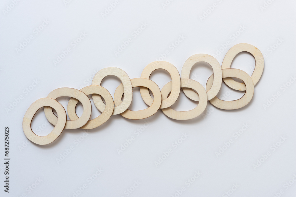 overlapping wooden letters O arranged horizontally on blank paper overlapping wooden letters O arranged horizontally on blank paper