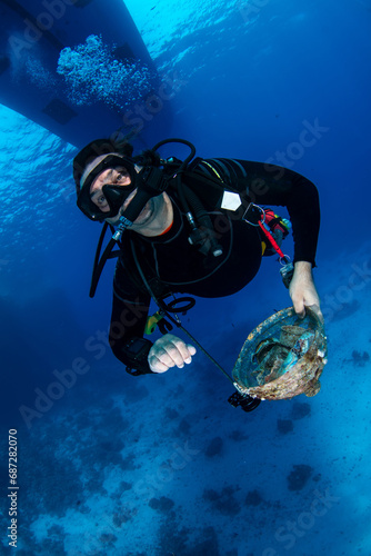 Diver collecting marine litter on the coral reef in Marsa Alam, Egypt