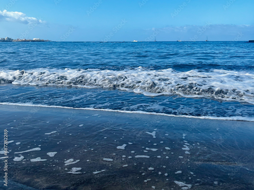 Naklejka premium Small ocean waves on the beach. Tenerife. Canarian Island. Amazing sky.