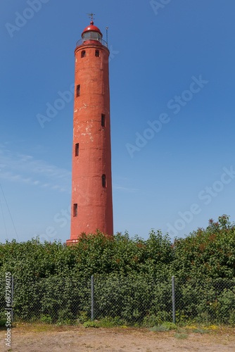 Akmenraga lighthouse in Latvia. Tall red tower.