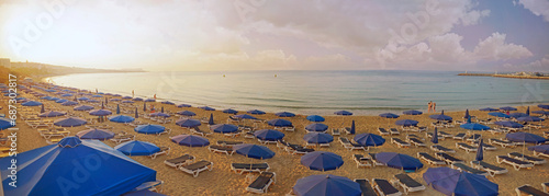 Panorama view of Pantachou Beach Glyki ,Nero Beach, Limanaki Beach and sea.Wonderful summer morning, blue beach umbrellas and sunbeds on sandy Beach in Ayia Napa, Cyprus. photo
