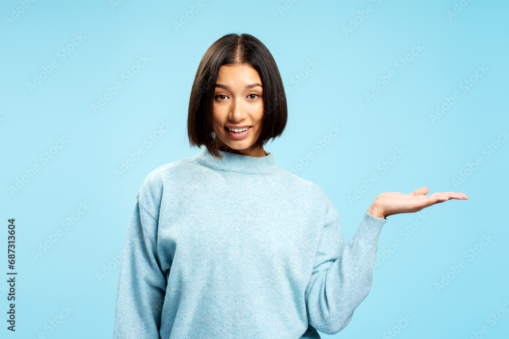 Attractive smiling Asian woman with stylish hairstyle wearing casual sweater holding hand copy space Attractive smiling Asian woman with stylish hairstyle wearing casual sweater holding hand copy space