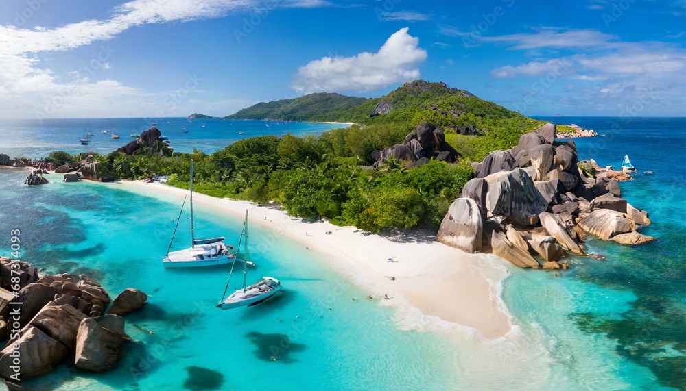 aerial pano of grand anse beach at la digue island in seychelles white sandy beach with blue ocean lagoon and catamaran yacht moored - obrazy, fototapety, plakaty 