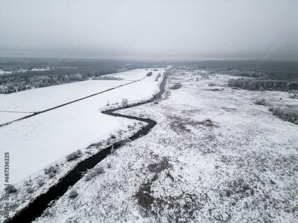 snow covered fields with river flowing in the centre