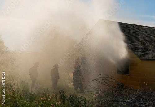 Firemen battle a house blaze that has consumed the entire building'