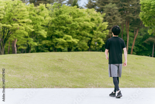 公園を歩く・ウォーキングする男性・スポーツマン・アスリート（全身） 