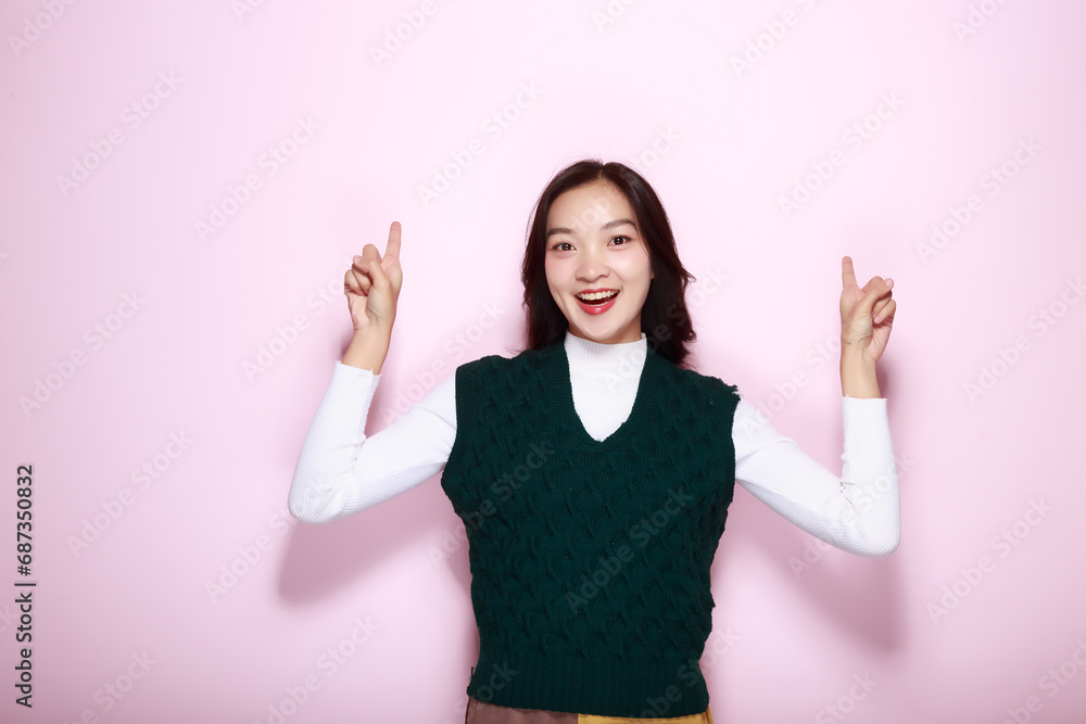 Standing and pointing happily, Portrait of a friendly young woman smiling happily, Beautiful girl on the pink background showing point fingers poses. Standing and pointing happily, Portrait of a friendly young woman smiling happily, Beautiful girl on the pink background showing point fingers poses.