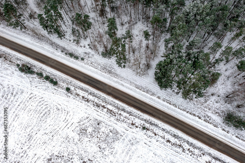 Aerial vertical view of the road going through a winter forest and a field, Lithuania © Krzysztof Bargiel