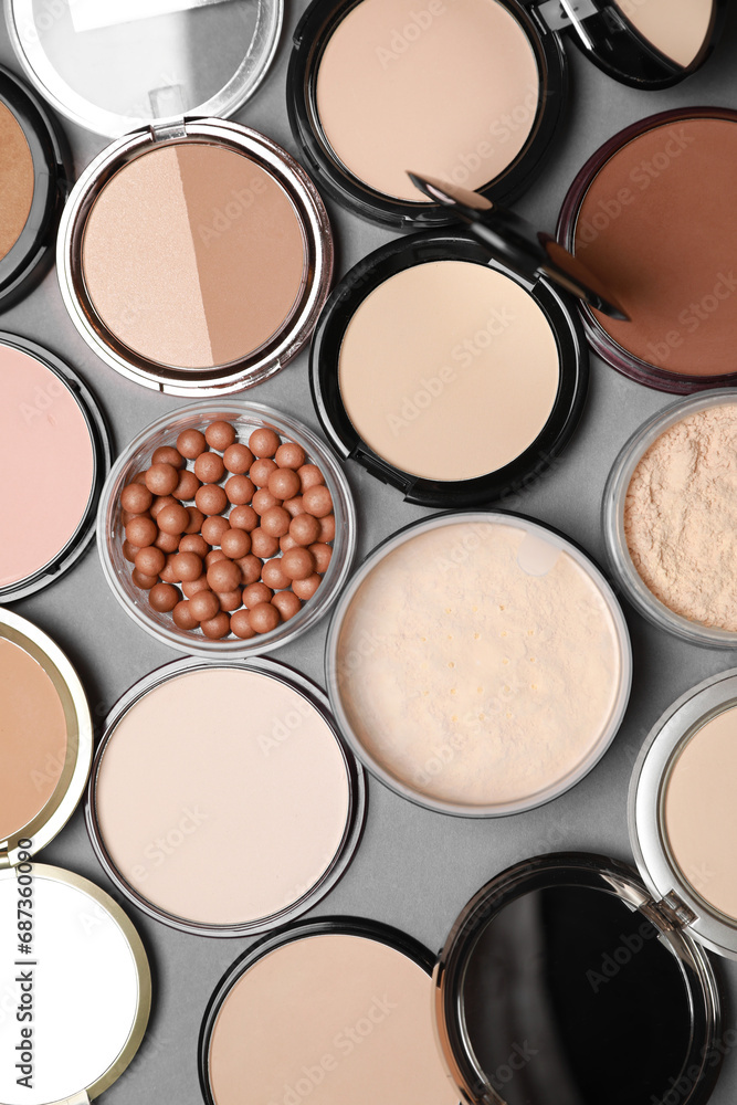 Different face powders on grey background, flat lay Different face powders on grey background, flat lay