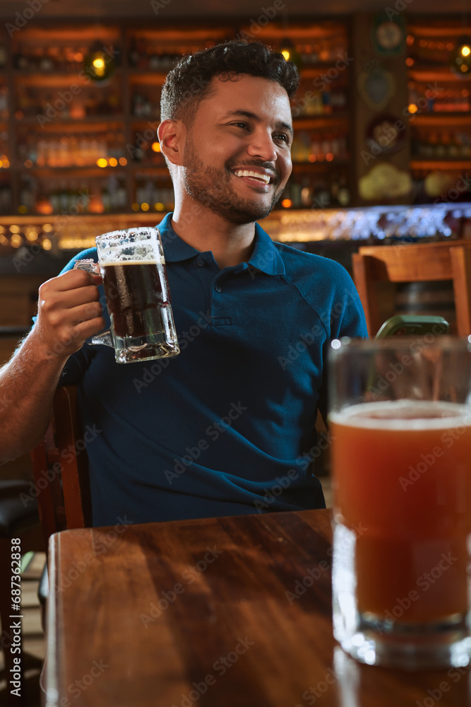 Hombre latino con una cerveza en un bar con colores calidos. con espacio para copy y diseños con expresiones 