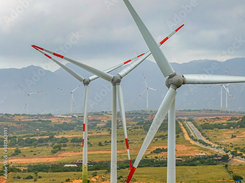 Panoramic view of wind farm or wind park, with high wind turbines for generation electricity with copy space on rice field, Ninh Thuan, Vietnam. Green energy concept.