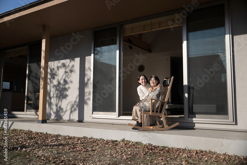 娘と母の高齢者介護の秋冬イメージ　仲良く会話する親子の広角 左にコピースペースあり © kapinon