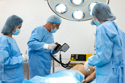 Professional anesthesiologist doctor team and assistant preparing patient to gynecological surgery performing operating, heart , pump at chest, cpr, save life in modern hospital emergency room