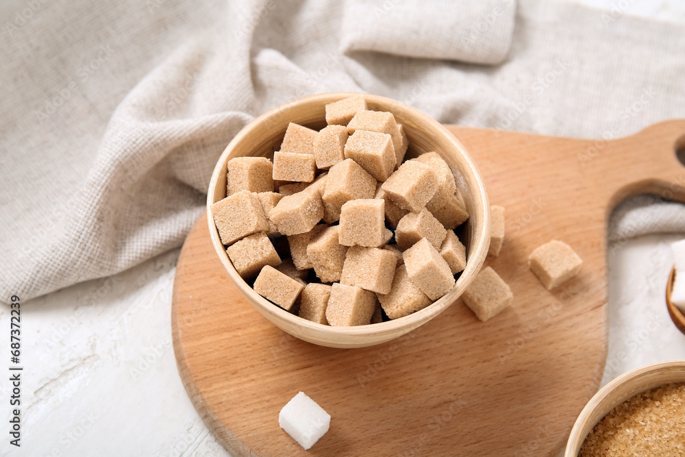 Bowl with brown cane sugar cubes on white background Bowl with brown cane sugar cubes on white background