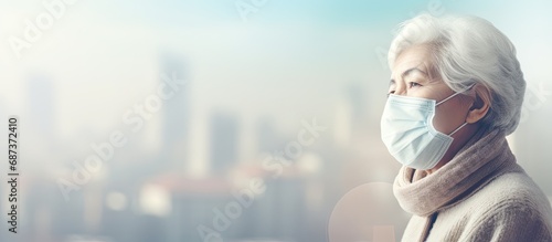 An elderly woman protects herself from city air pollution (PM2.5), which causes various health issues like lung cancer, allergies, asthma, and COPD. photo