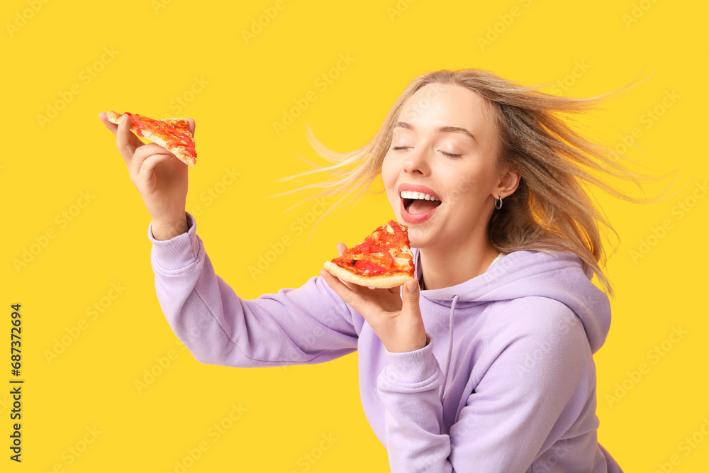 Young happy woman holding pieces of tasty pizza on yellow background Young happy woman holding pieces of tasty pizza on yellow background