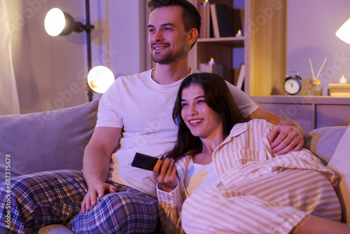 Young couple watching TV at...