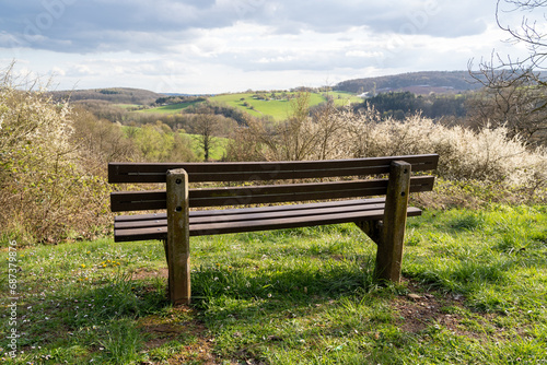 Wooden bench on the hill with a view of the beautiful landscape in spring