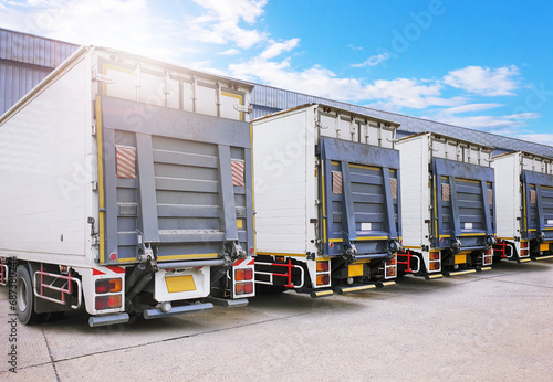 Container Trucks on The Parking Lot at Warehouse. Lifting Ramp Trucks. Commercial Truck Transport Lorry. Shipping Delivery Trucks. Distribution Warehouse. Freight Truck Logistics Cargo Transport
