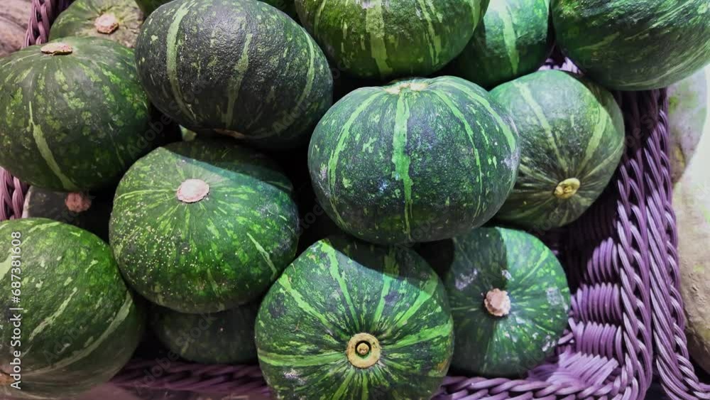 .pile of pumpkins in a basket..The benefits of pumpkin help prevent and reduce the risk of cancer..The green pumpkin has a rough surface and a beautiful pattern..The texture has a pattern background .pile of pumpkins in a basket..The benefits of pumpkin help prevent and reduce the risk of cancer..The green pumpkin has a rough surface and a beautiful pattern..The texture has a pattern background