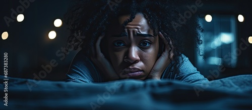 Stressed, exhausted black woman with mental health issues experiences insomnia, depression, and anxiety in her bedroom at night.