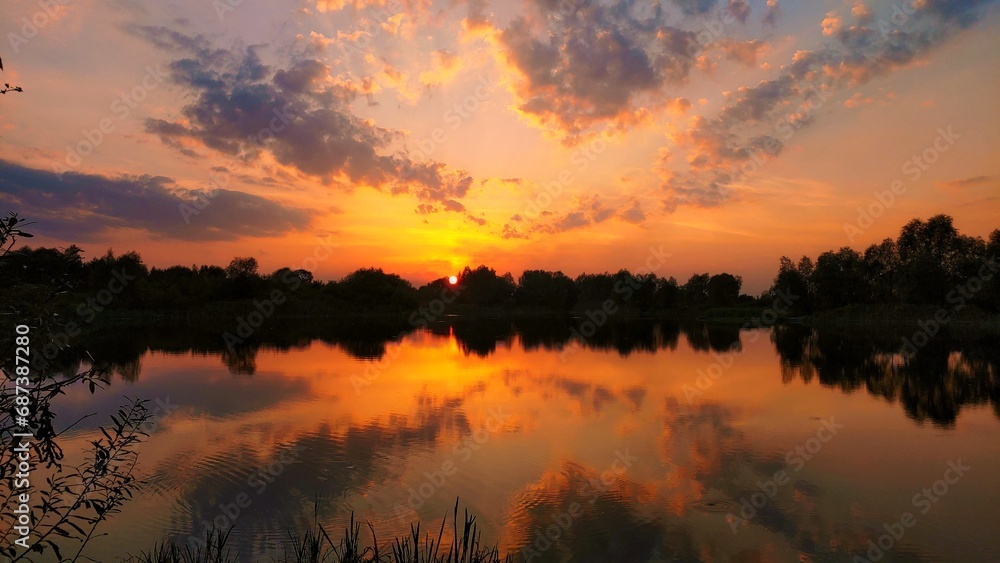 Fototapeta premium beautiful sunset sky and colorful clouds over the lake in summer with reflection in water