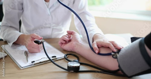 Doctor measuring blood pressure to man patient using tonometer closeup 4k movie slow motion. Diagnosis and treatment of arterial hypertension concept photo