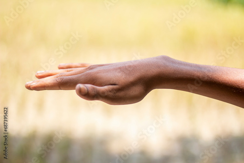 A man is holding his hand up and the background is blurred © Rokonuzzamnan