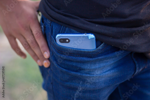 A mobile phone is half inside the pocket