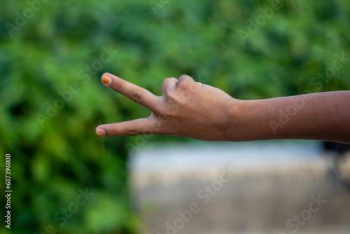 A man has his pointing two finger forward and blurred background © Rokonuzzamnan