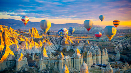 Amazing panoramic view of sunrise Cappadocia landscape with colorful hot air balloons in the love valley- Travel destination concept Turkey