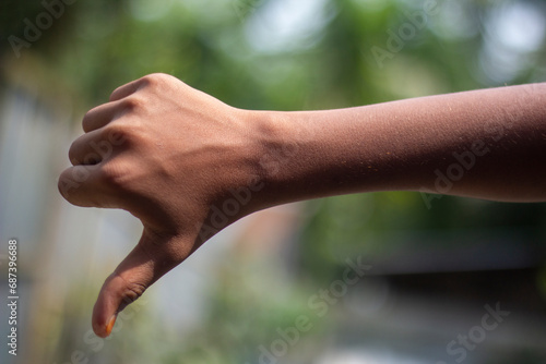 A man has his thumb pointing up and blurred background © Rokonuzzamnan