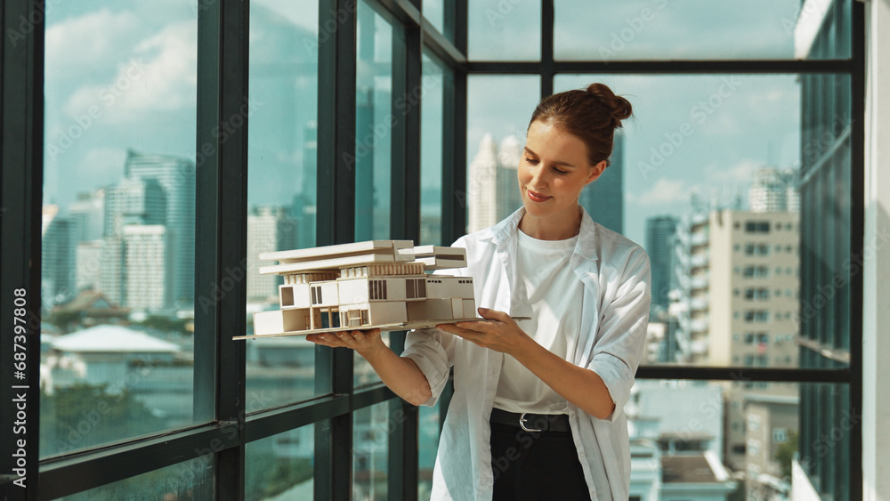 Young smart caucasian beautiful architect engineer raised house model