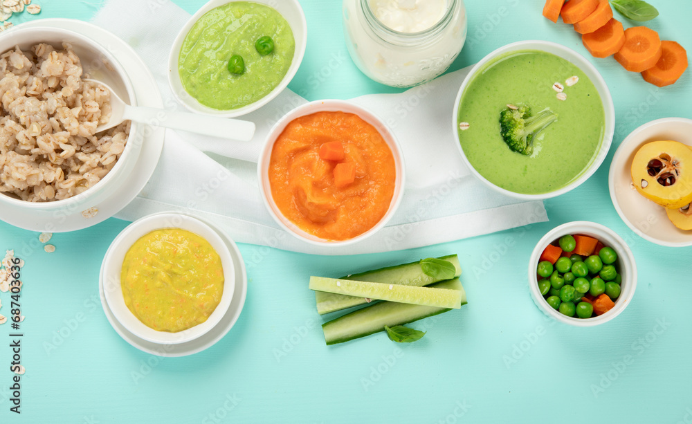 Bowls with different healthy baby food.