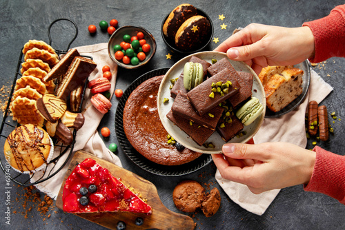 Tasty cake, cookies, waffles, macaroons, muffin. Delicious desserts on dark background. Food concept