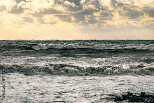 Beautiful sea waves during a storm. The Black Sea in a storm. Waves during a storm at sea. An epic seascape. Big waves crashing on the shore under a cloudy sky. View of the stormy seascape.